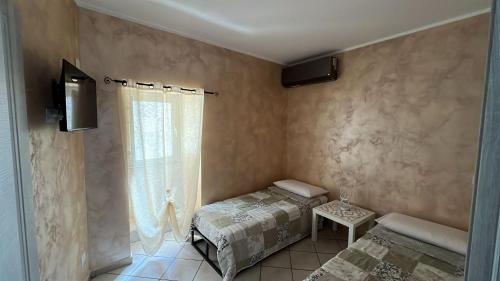 a small room with a bed and a window at Agherè in Agira