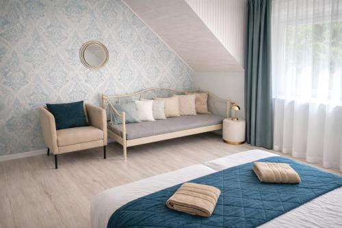 a bedroom with a bed and a couch and a chair at Iris Home in Székesfehérvár