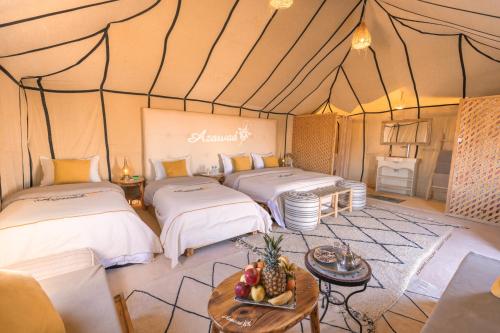a room with two beds in a tent at Azawad Desert Luxury Camp in Merzouga