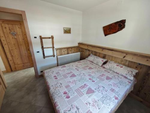 a bedroom with a bed with a quilt on it at MB Appartamento in Santo Stefano di Cadore