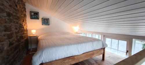 a bedroom with a bed in a room with a ceiling at En aparté in Vielsalm
