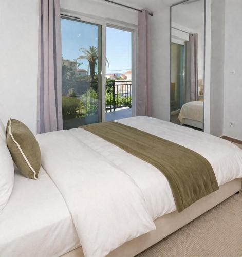 a bedroom with a large bed with a large window at Villa Verde Royal in Kaštela