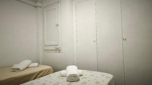 a small white room with two beds and towels at Hollywood Palazzo in Roses