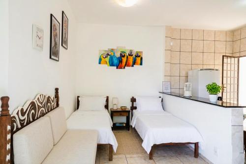 two beds in a room with white walls at Casa Inteira Com Total Privacidade e Quintal in Pará de Minas
