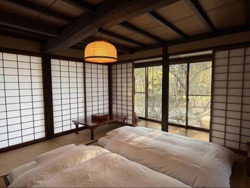 a bedroom with two beds in a room with windows at 甘糟屋敷 Amakasu Yashiki KAMAKURA in Kamakura