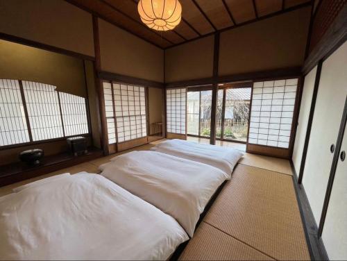 a large bed in a room with windows at 甘糟屋敷 Amakasu Yashiki KAMAKURA in Kamakura