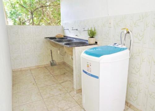 a kitchen with a sink and a trash can at Casa Inteira Com Total Privacidade e Quintal in Pará de Minas