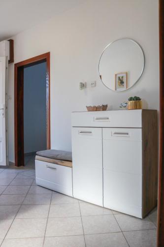 a white bathroom with a counter and a mirror at Kuća za odmor Franca in Ozalj