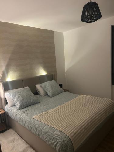 a bed with two pillows on it in a bedroom at L'Escale Gare Châteaucreux avec Garage in Saint-Étienne