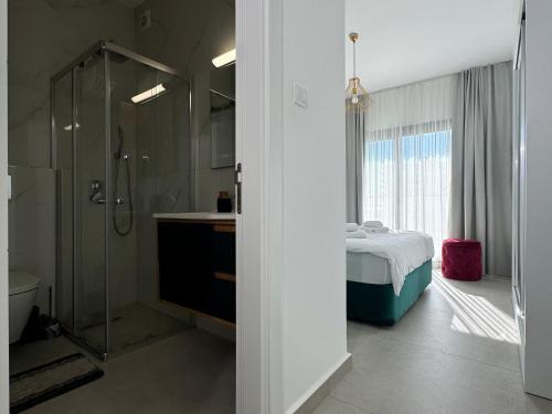 a bathroom with a shower and a bed in it at Nothern Cyprus Caesar Resort & Spa Collection Pools & Long Beach in Aglantzia