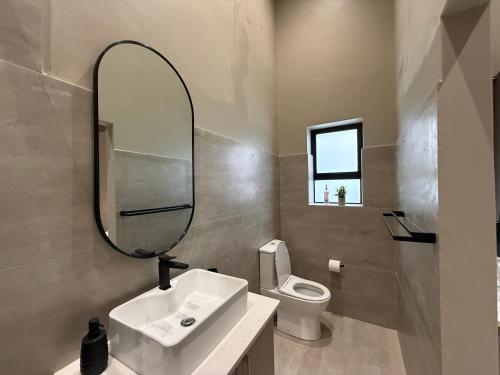 a bathroom with a sink and a mirror and a toilet at Autumn's Rest in George