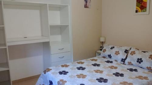 a bedroom with a bed with a floral bedspread at Casa brisas del rey in San Antonio de Arredondo