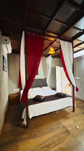a bedroom with a bed with red and white curtains at The Western Inn in Mananthavady