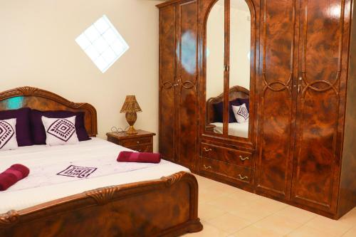 a bedroom with a wooden bed and a mirror at Kandy downtown villa Monza in Bahirawakanda