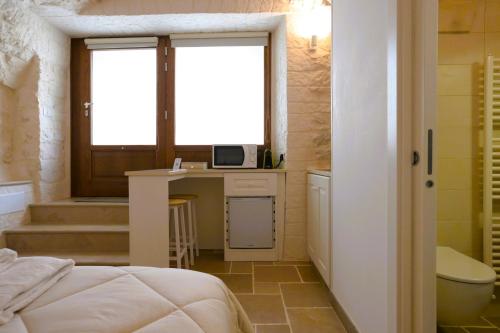 a bedroom with a bed and a desk with a microwave at Arcobaleno in Locorotondo