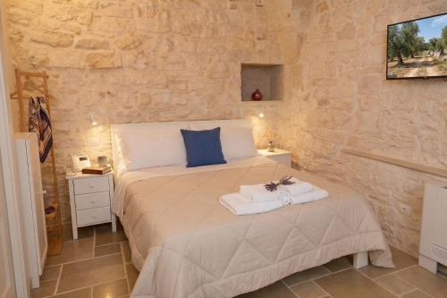 a bedroom with a bed in a stone wall at Arcobaleno in Locorotondo