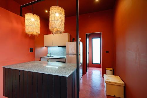 a kitchen with orange walls and a counter with a refrigerator at Afro Pool Villa Bangsean 01 in Ban Puk (2)
