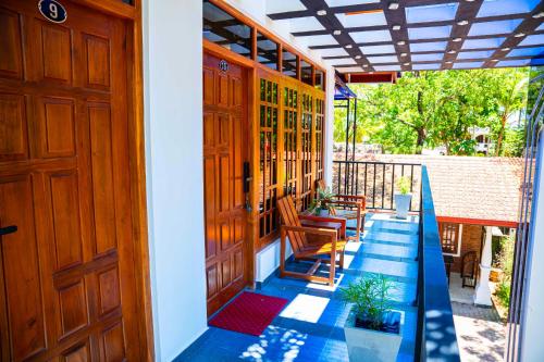 a porch with a door and a table and chairs at So-J Beach Villa in Trincomalee