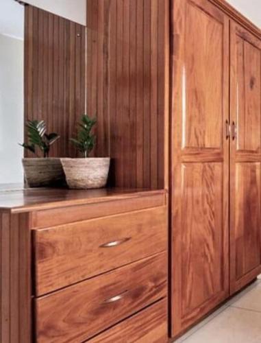 a wooden cabinet with two potted plants on it at Cozy Modern flat in Tunapuna