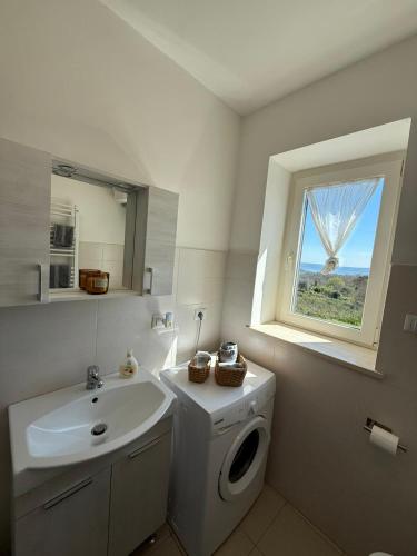 a bathroom with a sink and a toilet and a window at Silent Lake View in Valentano