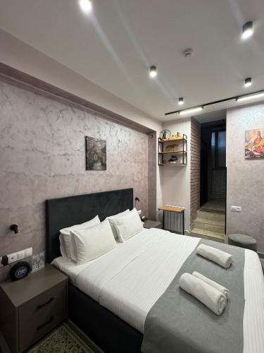 a bedroom with a large bed with towels on it at Avenue 23 Boutique Hotel in Yerevan
