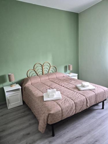 a bedroom with a large bed with two towels on it at Ca d'la Mondina Apartment in Vercelli