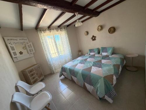 a bedroom with a bed and two white chairs at Le PATIO Beau Duplex terrasse 2 chambres 5mn théâtre antique in Orange