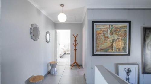 a room with a hallway with a painting on the wall at Villa Oceanic Escape in Hout Bay