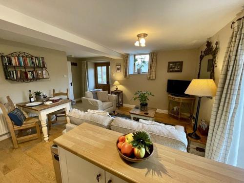 a living room with a bowl of fruit on a table at Gooseyard at Middle Farm and Cottages in Picklescott