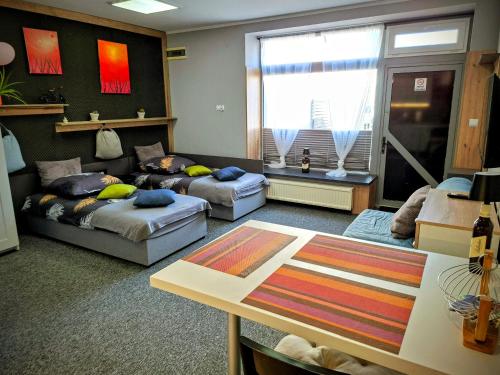 a living room with two beds and a table at Apartament Na Reymonta in Starogard Gdański