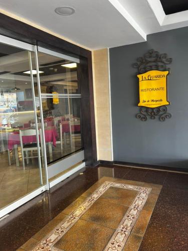 a restaurant entrance with a yellow sign on the wall at Hotel Colibrí Suites in Porlamar