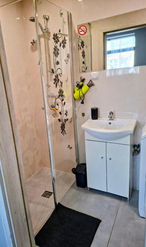 a small bathroom with a sink and a shower at Apartament Na Reymonta in Starogard Gdański