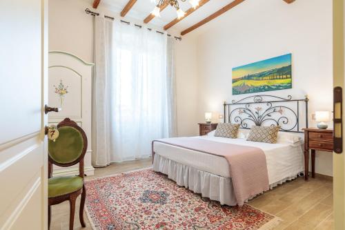 a bedroom with a large bed and a chair at Villa Fontis Rapolano in Rapolano Terme