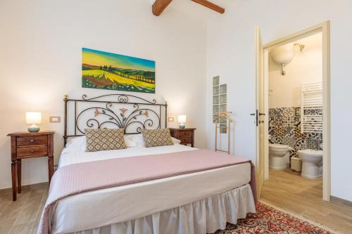 a bedroom with a large bed with a painting on the wall at Villa Fontis Rapolano in Rapolano Terme
