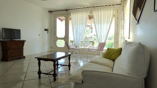 a living room with a white couch and a table at La Villa Rosa al Mare in Pozzallo