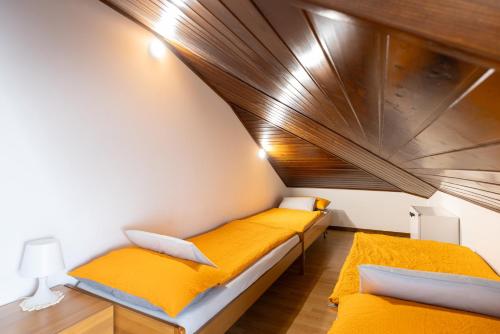 two beds in a room with a wooden ceiling at Uno Due Tre Stella in Chioggia