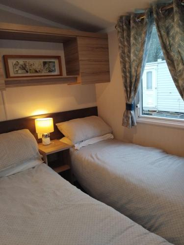 two beds in a small room with a window at Sunny sands retreat in Skipsea