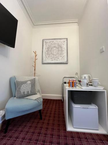 a living room with a chair and a desk at The Lili & Orchid Guesthouse in Oban
