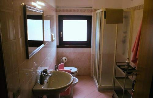 a bathroom with a sink and a toilet and a window at AR House in Clusane sul Lago