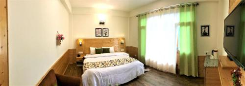 a bedroom with a bed and a large window at Devdar Heights in Jagatsukh