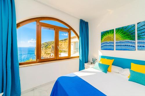 a bedroom with a bed and a large window at Estate4home - Suites Margar in Massa Lubrense