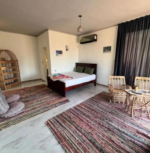 a bedroom with a bed and a table and chairs at Heaven Dune Camp in Nuweiba