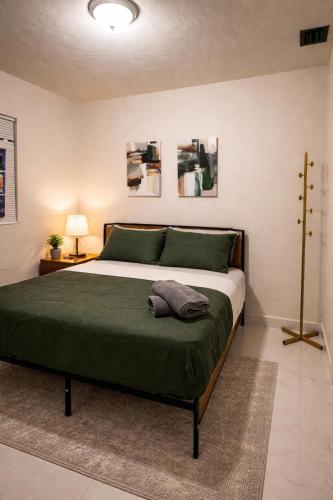 a bedroom with a large bed with a green blanket at Riio Shores in Miami