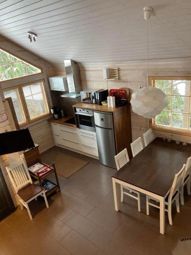 a kitchen and dining room with a table and chairs at Villa Nuttu - Loppusiivous kuuluu hintaan in Jämsä