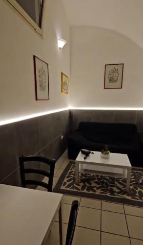 a living room with a table and a couch at Nonna Ninetta - Locazione Turistica in Orta Nova