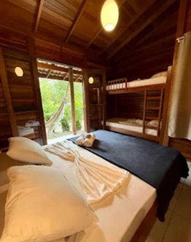 a bedroom with two bunk beds and a window at Pousadinha in Ilha do Mel