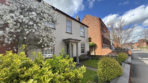 a house with a flowering tree in front of it at The Coach House in Melbourne
