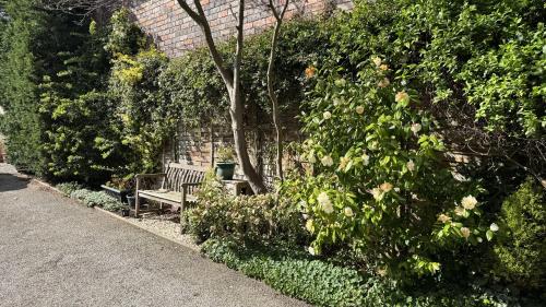 a park bench sitting next to a brick wall at The Coach House in Melbourne