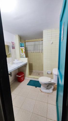 a bathroom with a toilet and a sink and a shower at Orlando house in Buritaca