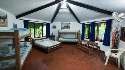 a room with two bunk beds and windows at Orlando house in Buritaca